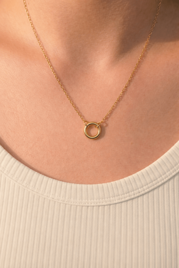 delicate gold chain necklace with round clasp worn on neck, designed as a base chain for charms
