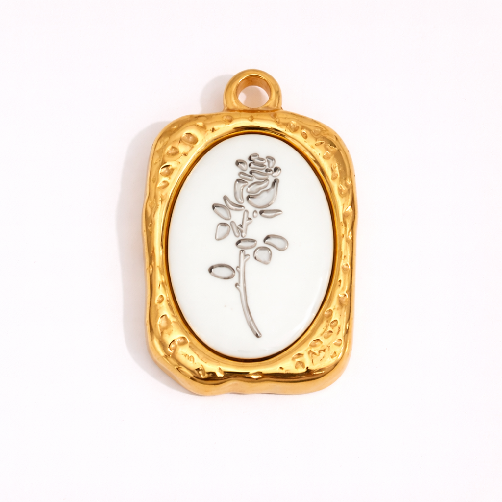 Gold framed charm with white background and rose illustration detail